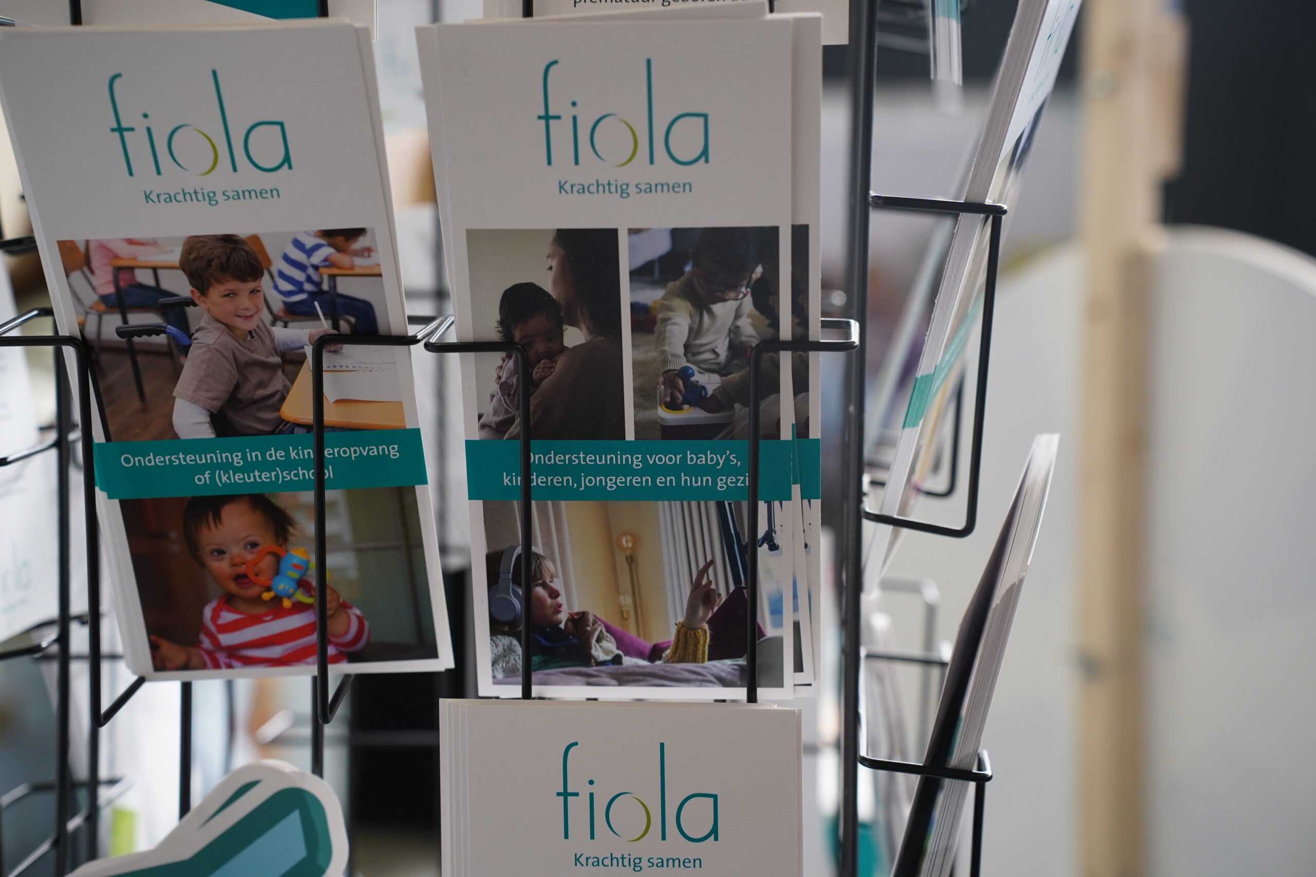 Brochurehouder met Fiola-folders over begeleiding en ondersteuning.