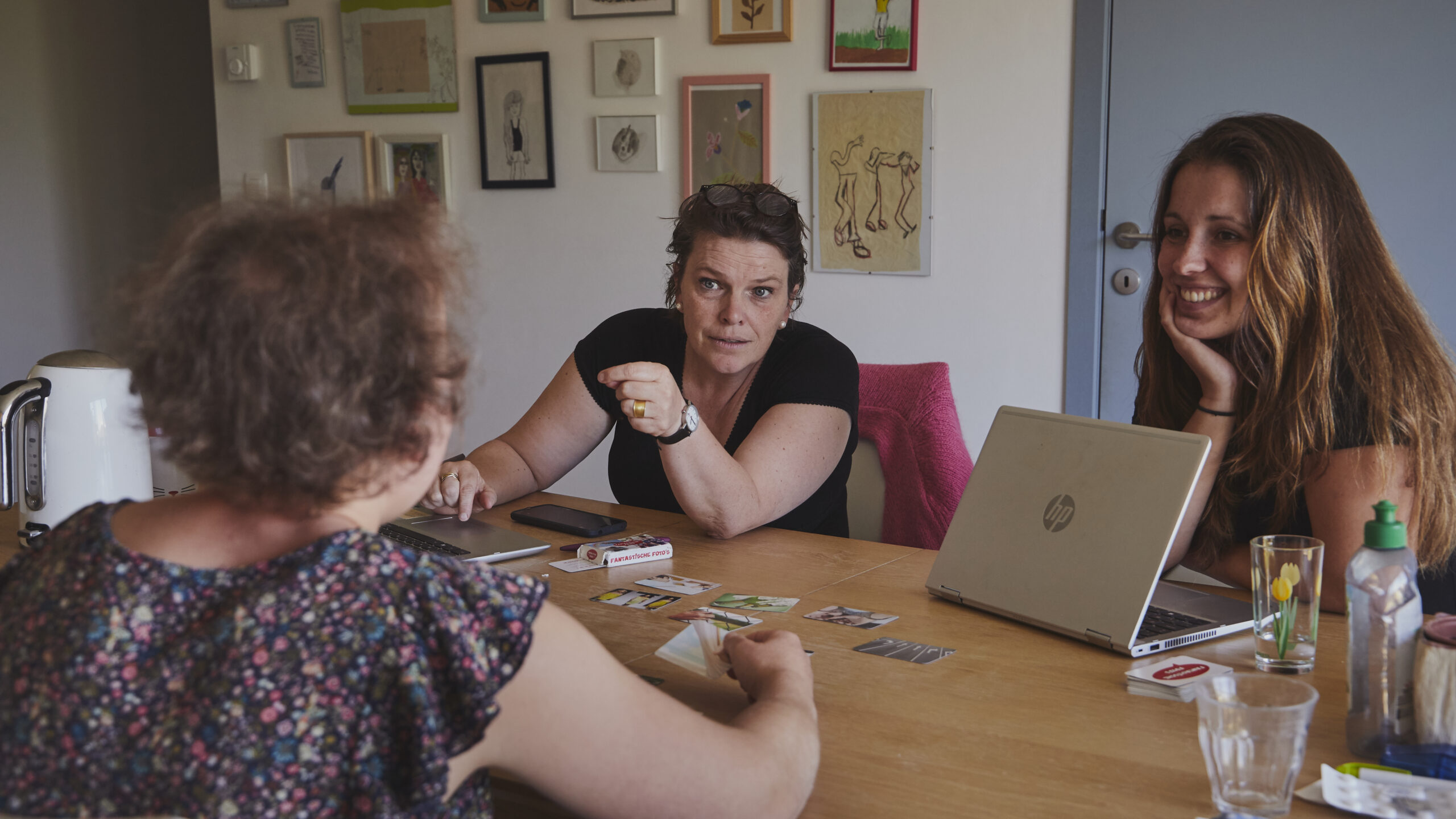 Drie vrouwn zitten rond een tafel
