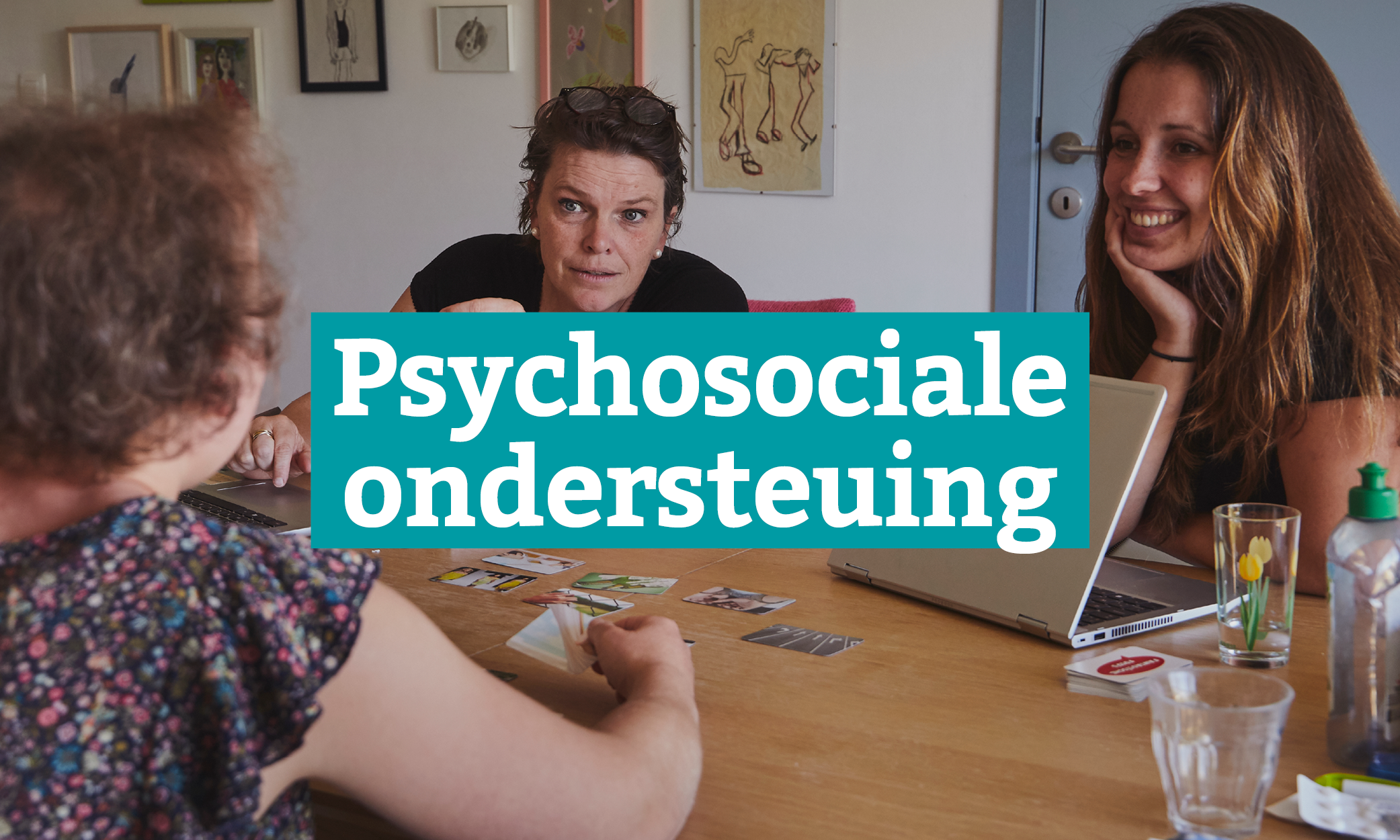 Op de foto zijn drie vrouwen te zien die aan een tafel zitten.